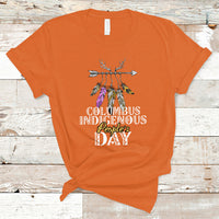 Orange T-shirt with colorful feather arrow graphic and “Columbus Indigenous People’s Day” text