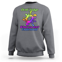 Charcoal gray sweatshirt with autism puzzle graphic: “Don't judge” and “What you don't Understand”