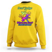 Daisy yellow sweatshirt with autism puzzle graphic: “Don't judge” and “What you don't Understand”