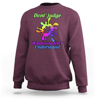 Maroon sweatshirt with autism puzzle graphic: “Don't judge” and “What you don't Understand”