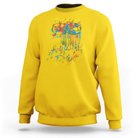 Yellow sweatshirt with colorful "Autistic Pride" graphic and glasses on back