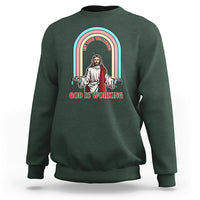 Dark forest green crewneck sweatshirt with rainbow Jesus graphic and text "God is working".