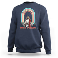 Navy crewneck sweatshirt with rainbow Jesus graphic and text "God is working".