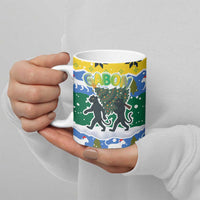 Gabon Christmas Ceramic Mug with Black Panthers Carrying Tree and Green Yellow Snowflake Pattern - Wonder Print Shop