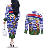 Gambia Christmas Couples Matching Off The Shoulder Long Sleeve Dress and Long Sleeve Button Shirt with Santa Birds Gift Boxes Forest Scene and Snowflake Pattern Design - Wonder Print Shop
