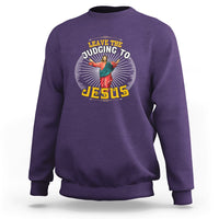 Purple sweatshirt with chest graphic reading “Leave the Judging to Jesus”