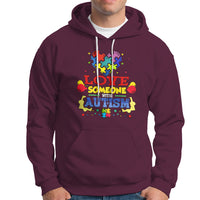 Maroon autism-themed hoodie with colorful front graphic, drawstring hood, kangaroo pocket.