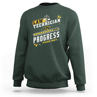 Dark forest green crewneck sweatshirt with filmstrip "In Progress" graphic and scales icon