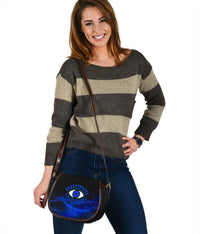 Blue evil eye crossbody saddle bag featuring black leather trim and flap