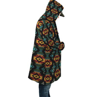 Hooded cloak side view, dark geometric print with red and teal accents, draped cut