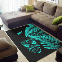 Turquoise fern motif and Maori mask graphic rug laid on floor, dark base