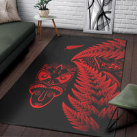 Black rug with red fern foliage and Māori tiki mask graphic