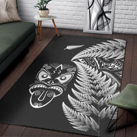 Black rug with white fern fronds and Maori face mask artwork on corner