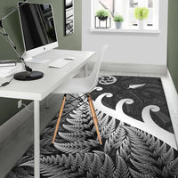 Black rug with white koru swirl and fern leaf motif, edge-to-edge pattern