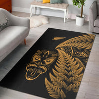 Black rug with gold tiki mask, ornate patterns, and fern fronds motif