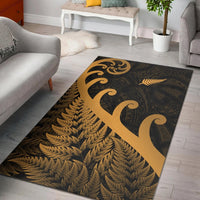 Gold fern and koru motif area rug with dark patterned background, rectangular