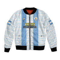 Bomber celeste y blanco con “Vamos Argentina”, escudo AFA y ribetes negros.