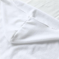 White woven towel fabric close-up with stitched edge and textured loops