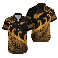 Hawaiian-style button-up shirt, dark fabric with gold fern and koru motifs, short sleeves