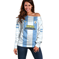 Suéter off-shoulder celeste y blanco con “VAMOS ARGENTINA” y escudo AFA