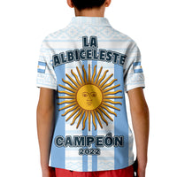 Polo infantil azul con espalda LA ALBICELESTE, sol dorado y CAMPEÓN 2022