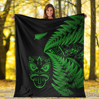 Black blanket outdoors with green fern leaves and Maori mask graphic