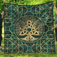 Teal quilt laid flat with gold Tree of Life and triquetra, geometric frame