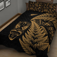 Black quilted bedspread with gold fern waves and Maori face symbol; two matching pillows