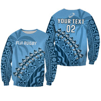 Blue unisex rugby sweatshirt with custom text, number 02, and tapa pattern