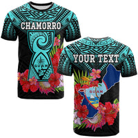 Turquoise and black T-shirt with CHAMORRO text, floral graphic and guam emblem.