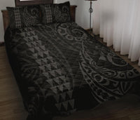 Grey patterned quilt cover on bed with two matching pillows, geometric triangles and swirls