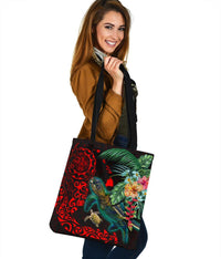 Black tote bag with red turtle artwork, tropical flowers and palm leaves, long strap handles.