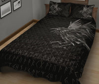 Black quilt set on bed, quilted surface with rune symbols and large raven feather motif