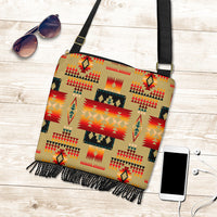 Light tan crossbody bag with multicolor geometric pattern, black fringe bottom, adjustable strap