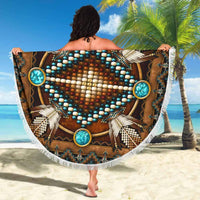 Round fringed beach blanket with bold turquoise medallion and white feather-like rays on brown