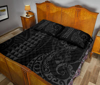 Grey quilt bed set with dark geometric triangles and swirl motifs; includes matching pillows