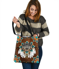 Brown tote bag with wolf face, turquoise diamond trim and teal button accents, held upright