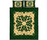 Green Hawaiian quilt with cream medallion and leafy border, plus two matching decorative pillows