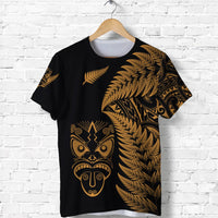 Black T-shirt with gold fern pattern and stylized tribal mask front print