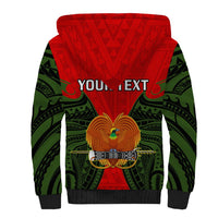 Sherpa hoodie with red center panel, green tribal wing graphic, and black cuffs