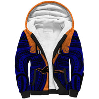 Orange sherpa hoodie with white plush lining, navy tribal print, black trim, hood.