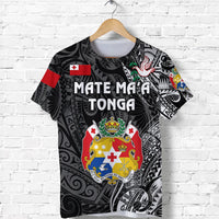 Black T-shirt front: “Mate Ma'a Tonga” lettering with red cross emblem and crest