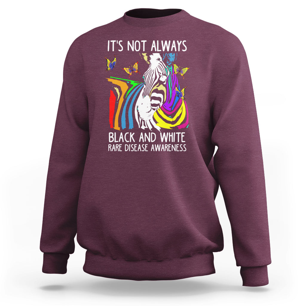 Kids maroon crewneck sweatshirt with zebra and rainbow awareness graphic on front.