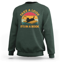 Forest green sweatshirt with cat reading book graphic and circular text print.