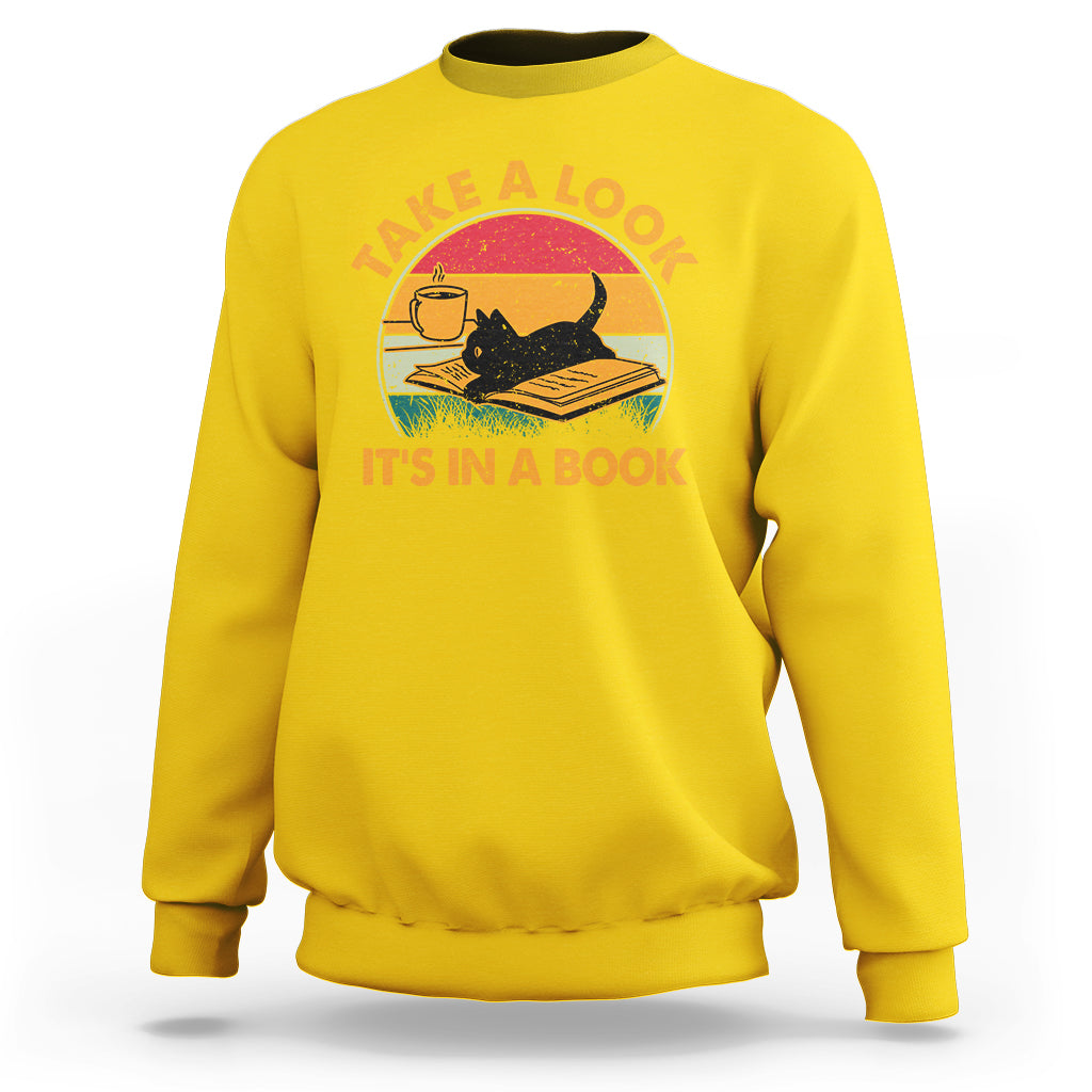 Daisy yellow sweatshirt with cat reading book graphic and circular text print.