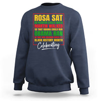 Dark blue crewneck sweatshirt with colorful 'Rosa Sat' and 'Celebrating' front graphic