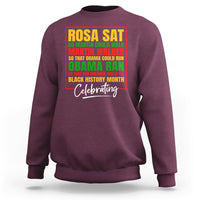 Maroon crewneck sweatshirt with colorful 'Rosa Sat' and 'Celebrating' front graphic