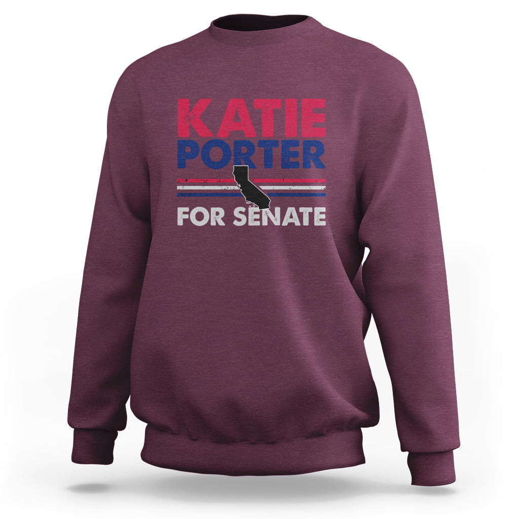 Maroon crewneck sweatshirt with front graphic text: KATIE PORTER FOR SENATE