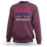 Maroon crewneck sweatshirt with front graphic text: KATIE PORTER FOR SENATE
