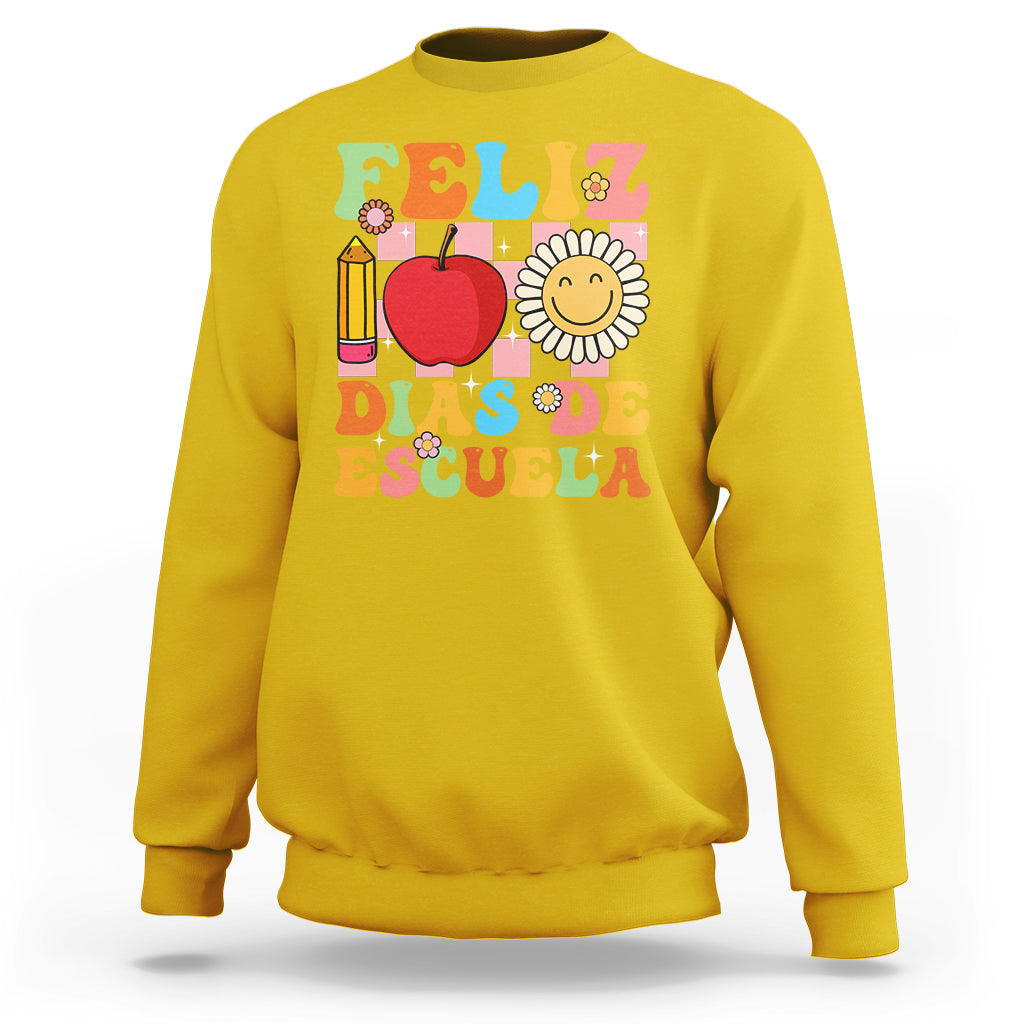 Yellow sweatshirt with colorful Feliz 100 Days of School graphic, apple, pencil, and flower